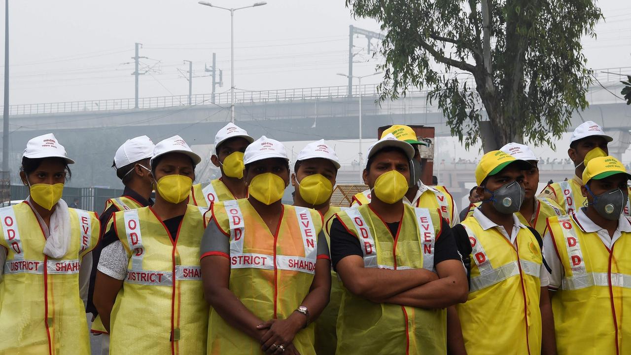 Volunteers from civil defence are forced to wear masks while working outside in Delhi. Picture: Prakash Singh / AFP