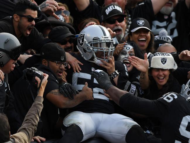 OAKLAND, CA - NOVEMBER 27: Khalil Mack #52 of the Oakland Raiders celebrates in the stands after scoring on an interception of Cam Newton #1 of the Carolina Panthers in the second quarter of their NFL game on November 27, 2016 in Oakland, California. Thearon W. Henderson/Getty Images/AFP == FOR NEWSPAPERS, INTERNET, TELCOS & TELEVISION USE ONLY ==