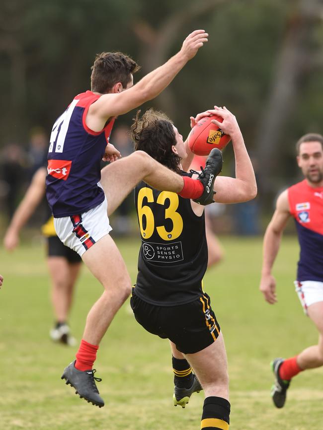 Mt Eliza’s Jem Thorne launches early as Seaford’s Bailey Schmidt takes a strong mark in front.