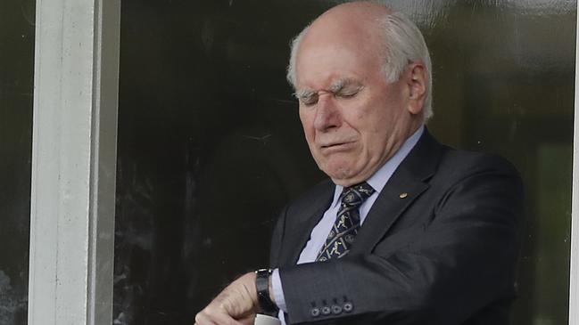 Former prime minister John Howard checks his watch during the rain delay on day three. Picture: Getty Images