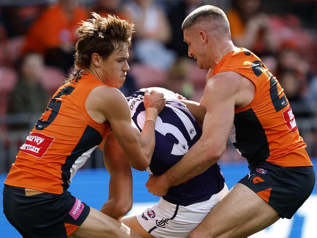 Giants Aaron Cadman and Jesse Hogan tackle Fremantle's Brandon Walker during the AFL Round 23 match between the GWS Giants and Fremantle Dockers at Engie Stadium on August 17, 2024. Photo by Phil Hillyard(Image Supplied for Editorial Use only - **NO ON SALES** - Â©Phil Hillyard )