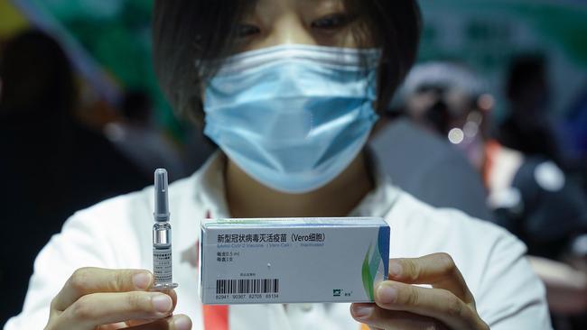 A China National Biotec Group employee holds a coronavirus vaccine at the 2020 China International Fair for Trade in Services at Beijing Olympic Park on Saturday, September 5. Picture: Getty Images