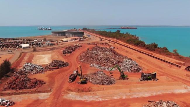 Trucks load scrap metal into a vessel for recycling at Gove, owned by Rio Tinto