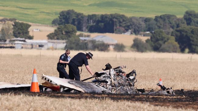 Officers inspect the plane’s wreckage. Picture: Russell Millard Photography