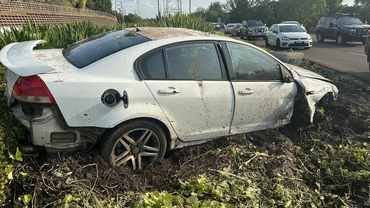 Windscreen smashed, tyre missing, airbags blown – the Holden Commodore sat in the garden bed as commuters caught a glimpse of the carnage from overnight. Picture: Elise Graham.