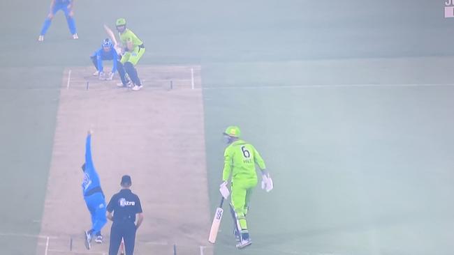 A TV grab shows Thunder and Strikers players in the smoke at Manuka Oval.