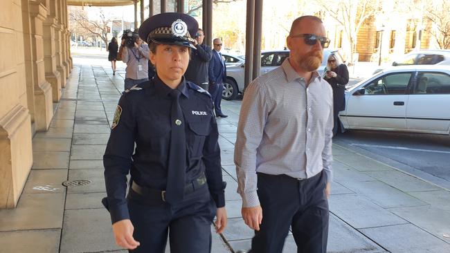 SA Police senior constable Susan Cabot outside the District Court with a supporter after giving an emotional account of the impact of Christopher George Smolinski's attack on her and colleague Aleisha Westby. Picture: Renato Castello