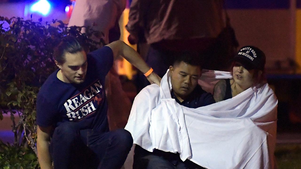 People comfort each other as they sit near the scene in Thousand Oaks. Picture: AP