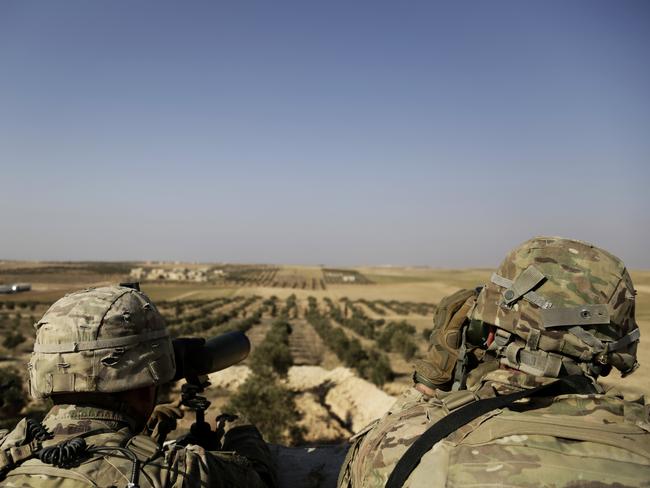 American troops looking over a battlefield from a small outpost in northern Syria. Picture: AP