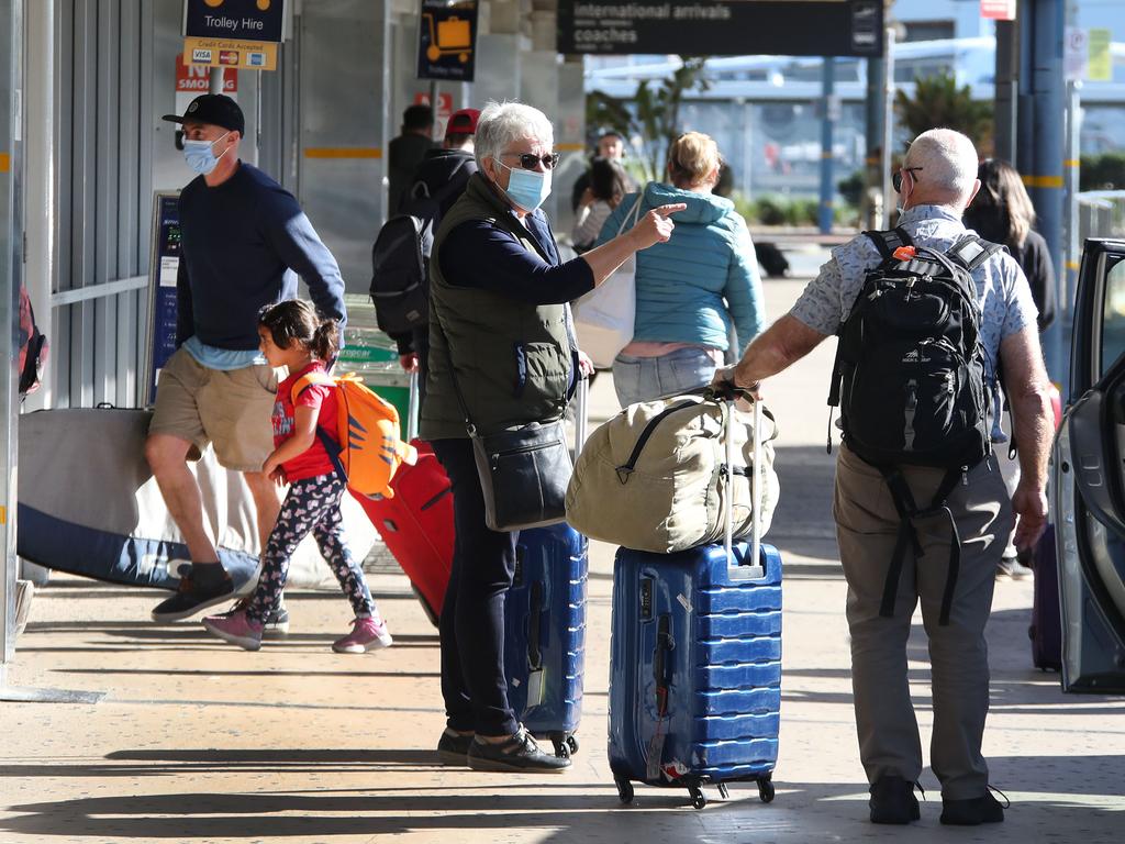 Travellers wearing masks at a quiet Gold Coast Airport. Picture Glenn Hampson