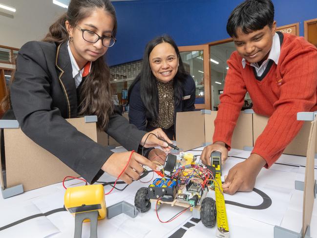 Suzanne Cory High School robotics and mathematics teacher Michelle Magalona in her classroom with some members of her year 10 robotics class, and the robotics they are working on. Ms Magalona was named Outstanding Early Career Secondary Teacher at last year's Victorian Education Excellence Awards for her work to increase student engagement in STEM disciplines. Ms Magalona, centre with year 10 robotics students, Amnah Adnan and Akash Mahalanabis. Picture: Tony Gough