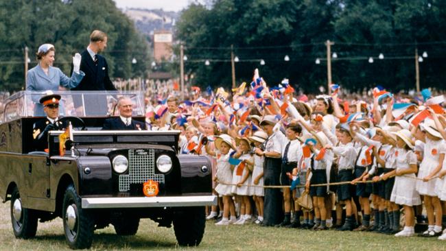 Queen Elizabeth II and Prince Philip waving to a crowd of children in Bathurst, NSW, during their royal tour, February 1954. Picture: Getty Images.