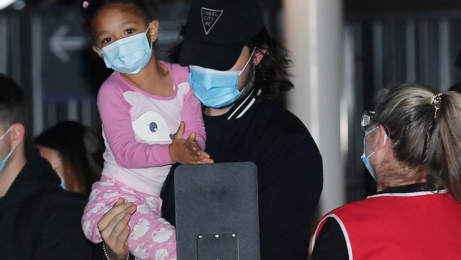 Alexis Olympia Ohanian Jr, daughter of Serena Williams, sterilises her hands while being held by her father, Alexis Ohanian, on their arrival at Adelaide Airport. Picture: Mark Brake/Getty Images