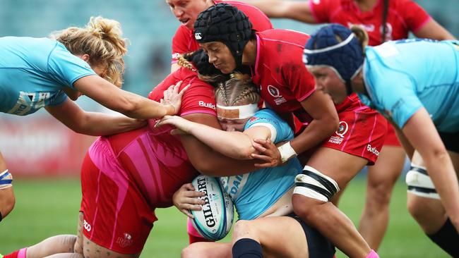 Emily Robinson of NSW is wrapped up by the Queensland defence in the Super W grand final on Friday.