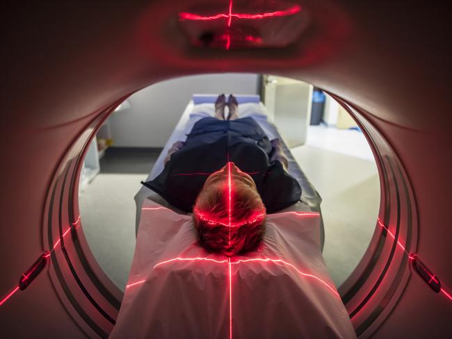 Person undergoing a CAT scan in hospital. PET scan equipment. Medical CT scan of patient.