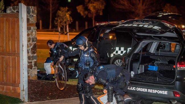 Dozens of police some in riot gear gather near Lonzo Park in Taylors Hill . Police also  blocked off part of Gourlay road. Picture: Jason Edwards