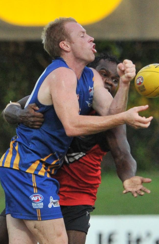 James McNamee (left) of Wanderers passes the ball while Shane Tipuamantmirri of Tiwi Bombers challenges.