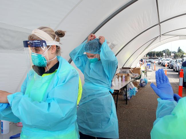 SYDNEY, AUSTRALIA - JULY 22: Registered Nurse's Kahala Dixon and Ali Murphy dress in PPE (personal protective equipment) at the COVID-19 drive-through testing clinic at Bondi Beach on July 22, 2020 in Sydney, Australia. New South Wales recorded 16 new COVID-19 cases on Wednesday, bringing the state's total number of coronavirus cases to 3,425. NSW residents are being urged to avoid non-essential travel and large crowds, as health authorities work to contain several COVID-19 cluster outbreaks across the state. Cases linked to the Crossroads Hotel, Thai Rock and Batemans Bay Soldiers Club clusters have been shown to all be linked to virus strains in Victoria, where residents are currently in lockdown due to the dramatic rise in community transmissions. (Photo by Lisa Maree Williams/Getty Images)