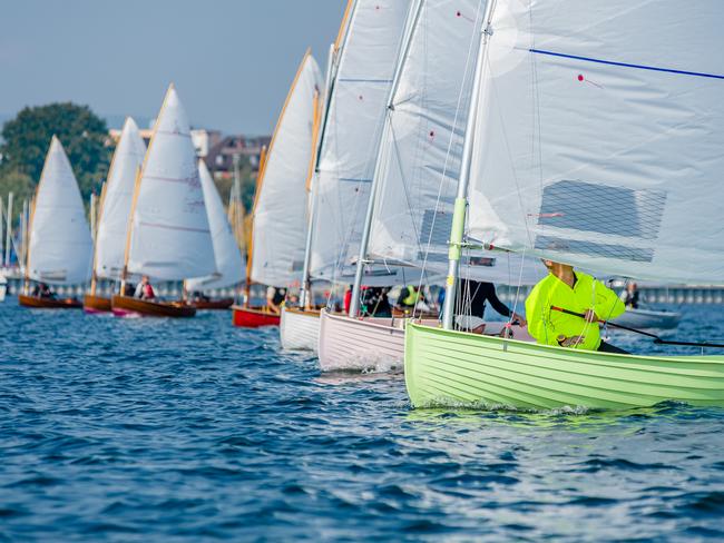 12 foot dinghies line up for the start of a regatta