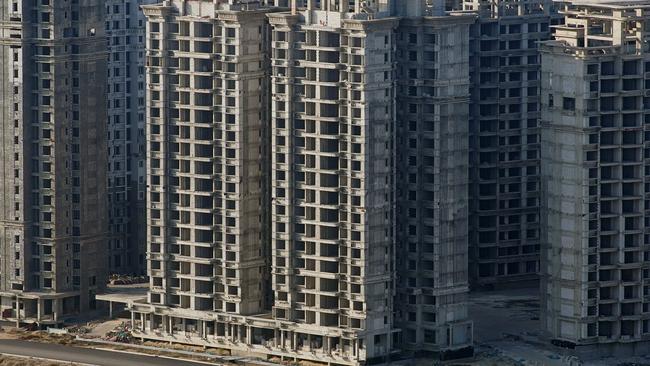 A vehicle travels past some of the 39 buildings developed by China Evergrande Group that authorities have issued demolition order on. Picture: Aly Song