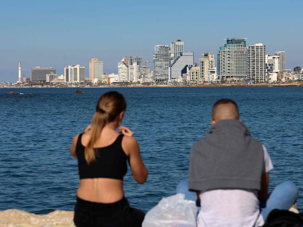 A young couple share a picnic in front of the Tel Aviv skyline. Picture: Emmanuel Dunand/AFP
