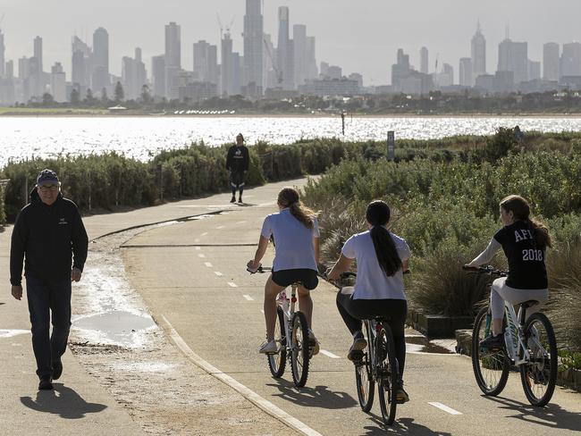 MELBOURNE, AUSTRALIA - MAY 13: People walk and ride along the beach at Brighton on May 13, 2020 in Melbourne, Australia. COVID-19 restrictions have eased slightly for Victorians in response to Australia's declining coronavirus (COVID-19) infection rate. From today, people in Victoria will be allowed to visit friends and family. A maximum gathering of up to ten outdoors is allowed, or up to five visitors inside a home. Golfing, hiking and fishing is also now permitted. (Photo by Daniel Pockett/Getty Images)