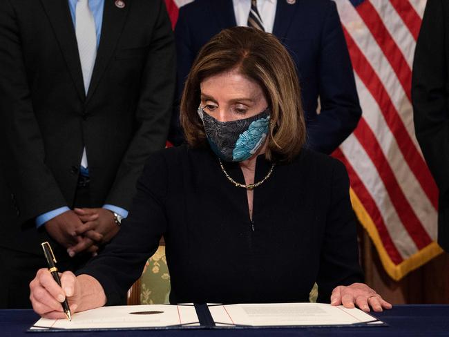 Speaker of the House Nancy Pelosi signs an article of impeachment against Donald Trump for the second time. Picture: AFP