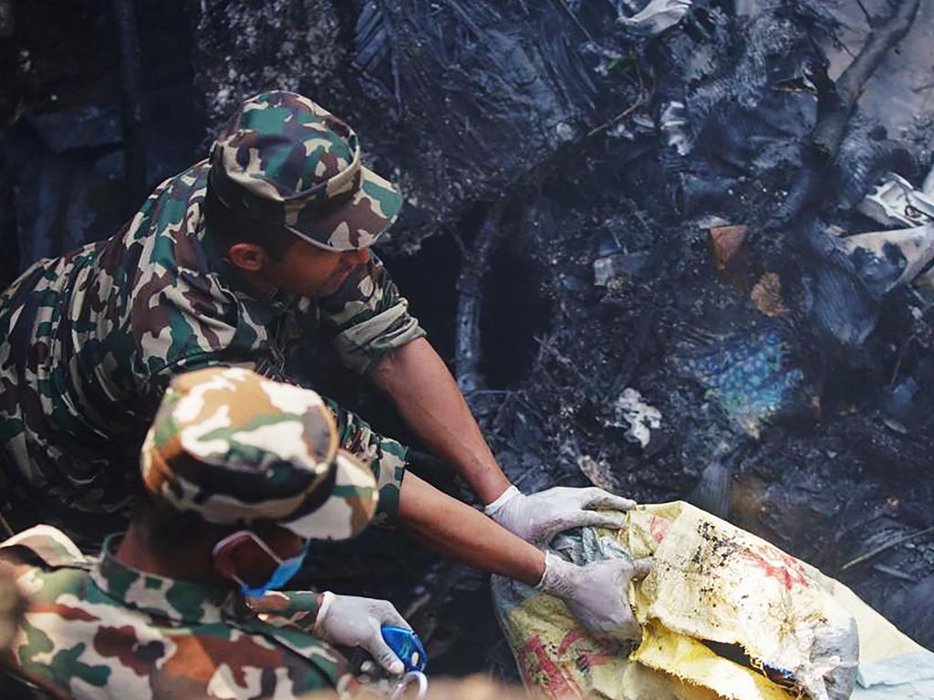 Rescuers inspect the site of the plane crash in Pokhara. Picture: Yunish Gurung / AFP