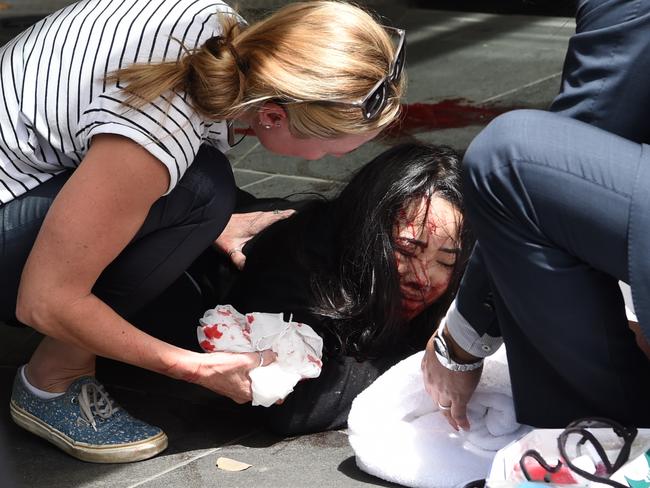 Passers-by help a bleeding and distressed young woman. Picture: Tony Gough