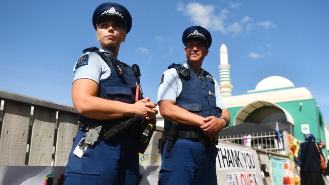 Police officers stand guard outside the Kilbirnie Mosque as part of the Human Chain of Protection and Solidarity in Wellington, yesterday. Picture: Getty Images 