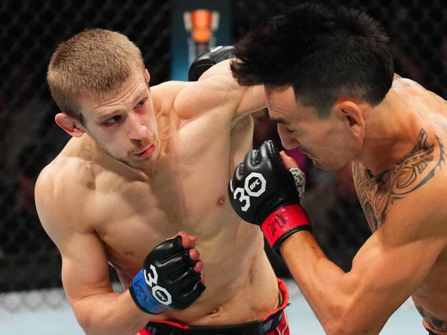 KANSAS CITY, MISSOURI - APRIL 15: (L-R) Arnold Allen of England punches Max Holloway in a featherweight fight during the UFC Fight Night event at T-Mobile Center on April 15, 2023 in Kansas City, Missouri. (Photo by Josh Hedges/Zuffa LLC via Getty Images)