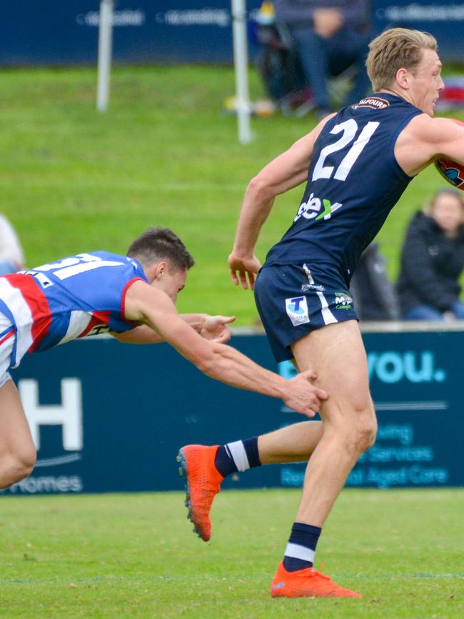 Corey Durdin tries to bring down South Adelaide’s Ben Heaslip at Elizabeth Oval last season. Picture: Brenton Edwards/AAP.