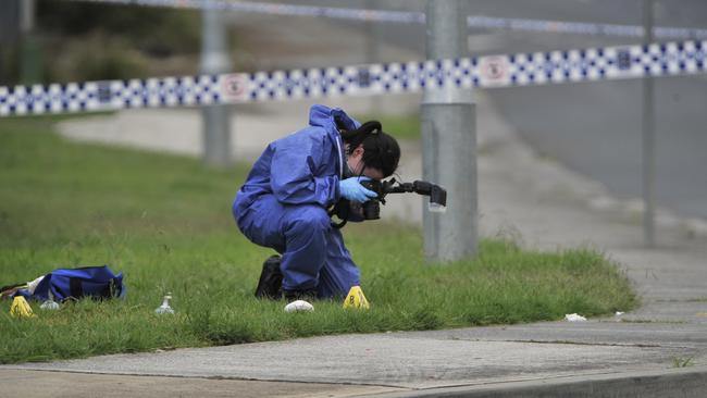 A forensics officer collects evidence from the scene after efforts to revive the woman — killed by a single bullet — failed. Picture: Robert Pozo.