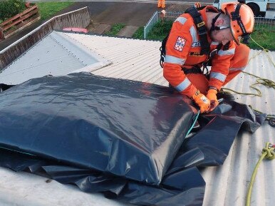 A﻿n SES Mersey member helping fix tarp on a home impacted by the flood.There was a moderate flood warning issues for﻿ the Mersey River on the north-west coast of Tasmania.  pic SES