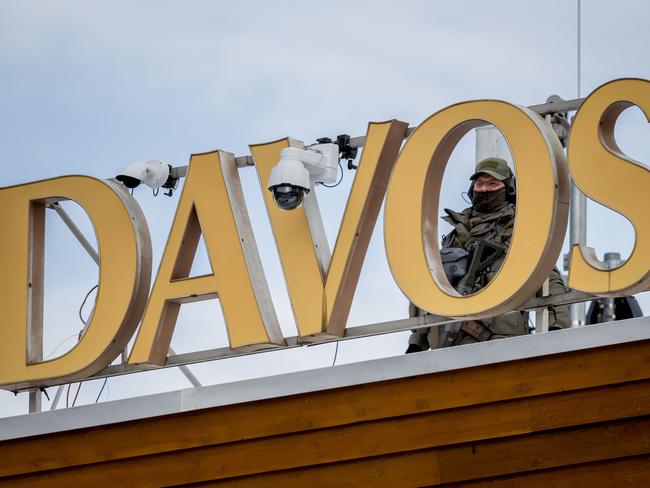 A sniper police officer stands on the top of the Congress hotel during the annual meeting of the World Economic Forum (WEF) in the Alpine resort of Davos on January 24, 2025. (Photo by Fabrice COFFRINI / AFP)