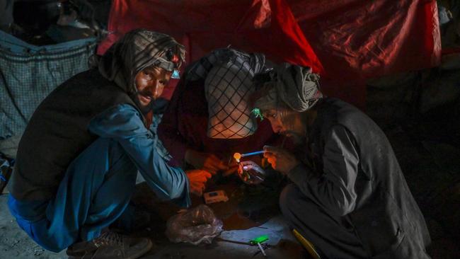 Drug users consuming drugs under a bridge where hundreds of addicted people gather in Kabul. Picture: AFP