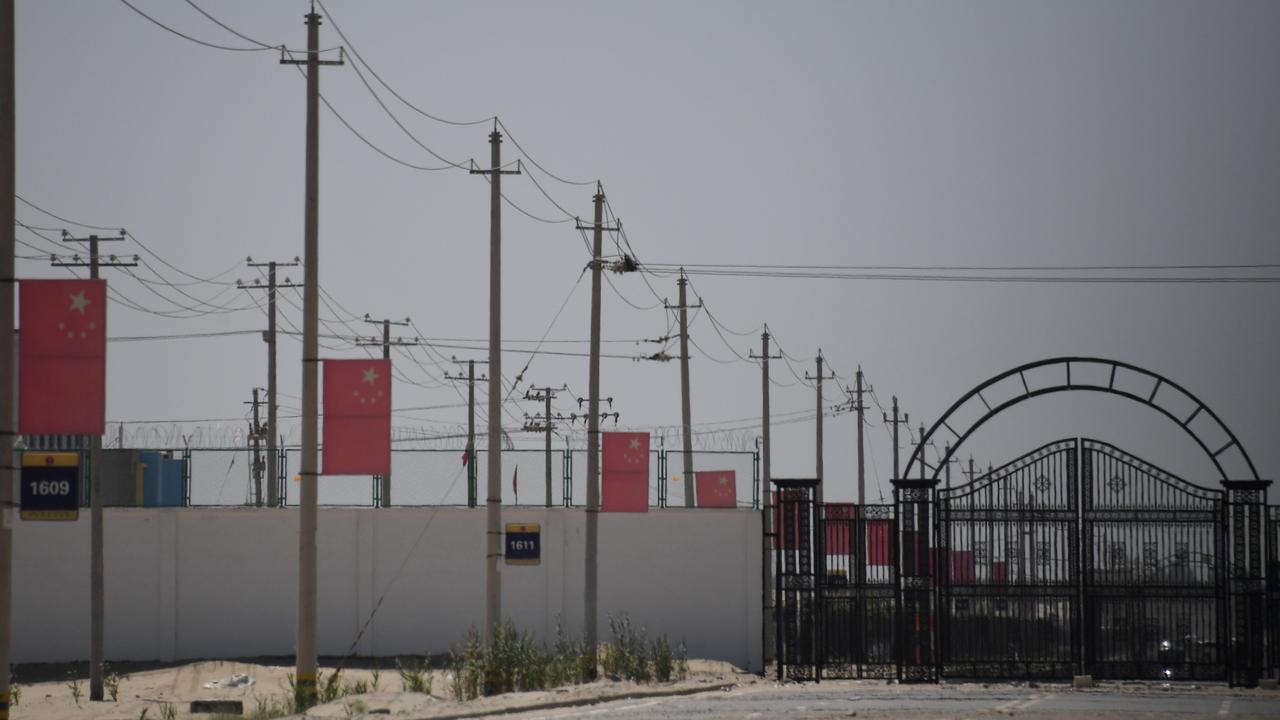 This photo taken in May 2019 shows Chinese flags on a road leading to a facility believed to be a re-education camp where mostly Muslim ethnic minorities are detained. Picture: Greg Baker / AFP