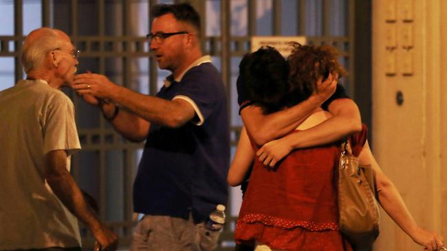 Shock: People embrace in shock after the Bastille Day tragedy. <i>AFP PHOTO / Valery HACHE</i>