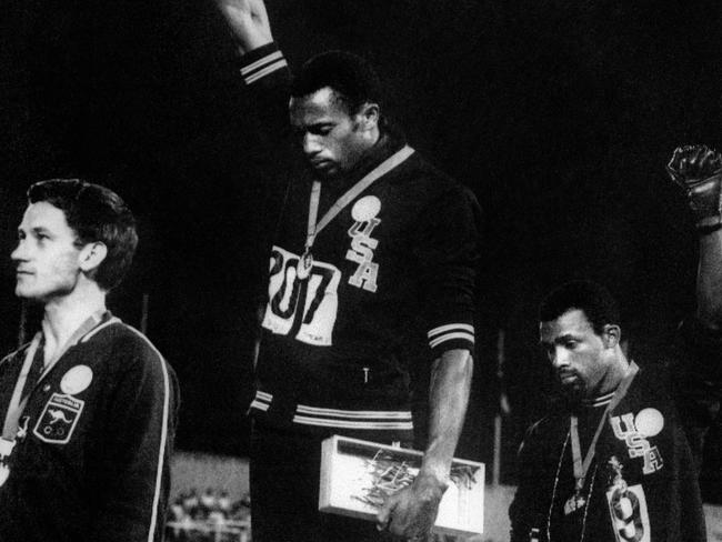 Tommie Smith (C) and John Carlos (R) raise their gloved fists in the Black Power salute at the Mexico City Olympics, with Peter Norman on the left.