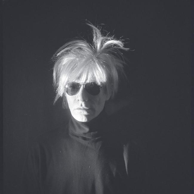 A self-portrait of Andy Warhol posing in a turtleneck and sunglasses, 1986.