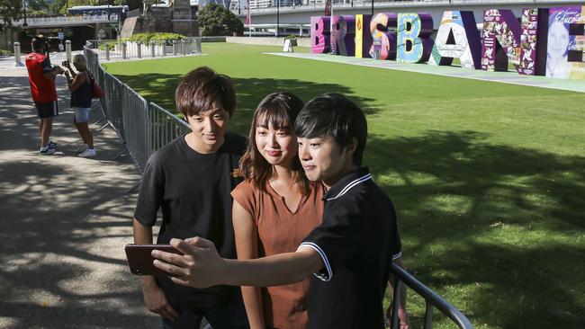 Japanese tourists Kosuke Urata, Arisa Sugaya and Eisuke Nasuno at South Bank in Brisbane. Picture: Mark Cranitch.