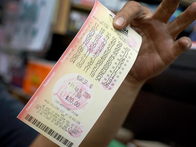 FORT LAUDERDALE, FLORIDA - AUGUST 04: A hopeful lottery ticket holder shows off his Mega Millions lottery ticket that he bought at Bob's News & Books store on August 04, 2023 in Fort Lauderdale, Florida. Ahead of this evening's drawing, the Mega Millions jackpot sits at an estimated $1.3 billion, the fourth-largest prize in the lottery's history.   Joe Raedle/Getty Images/AFP (Photo by JOE RAEDLE / GETTY IMAGES NORTH AMERICA / Getty Images via AFP)