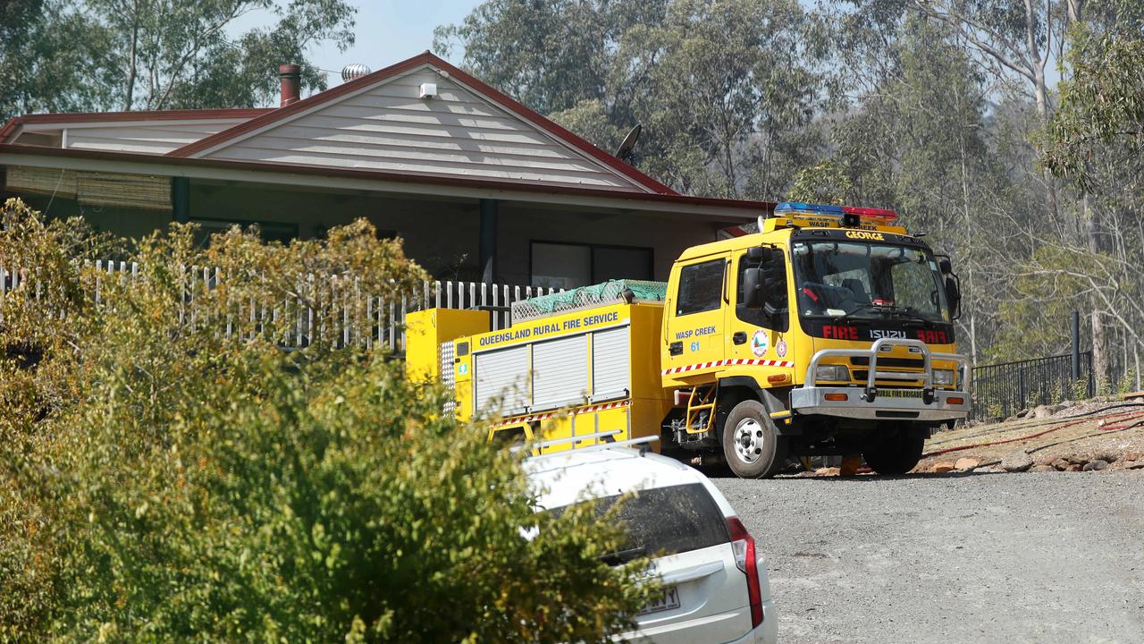 Firefighters brace for the worst as fires continue to burn in the Canungra and Sarabah regions. Melanie and Jamie Stevenson with their dogs Milky and Muttly had their home saved by firefighters on Lamington National Park Road in Canungra. Picture: NIGEL HALLETT