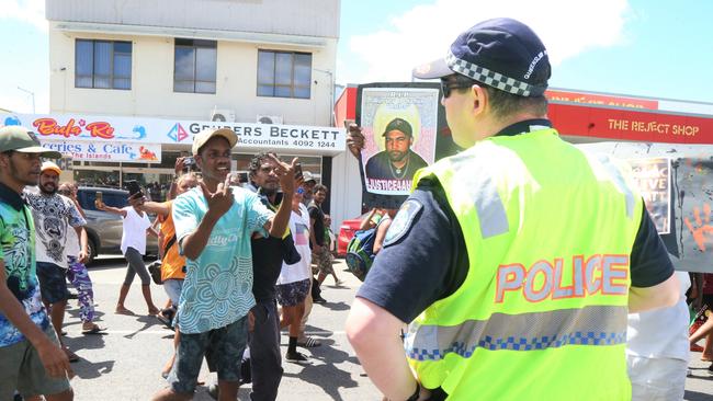 Angry protesters taunt police stationed along the route of a large protest in Mareeba on Monday. Picture: Peter Carruthers