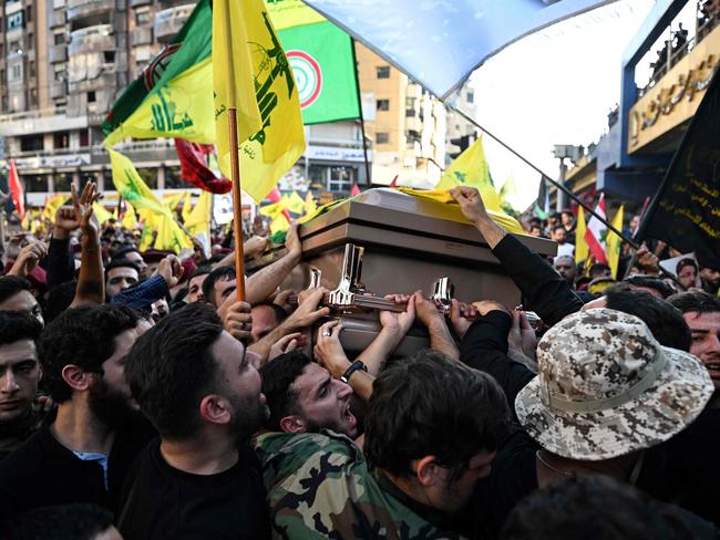 Hezbollah fighters and mourners carry the casket of slain top commander Fuad Shukr during his funeral in Beirut's southern suburbs. Picture: AFP