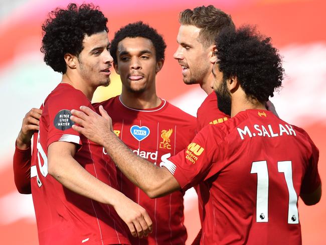 Liverpool's English midfielder Curtis Jones (L) celebrates scoring his team's second goal during the English Premier League football match between Liverpool and Aston Villa at Anfield in Liverpool, north west England on July 5, 2020. (Photo by Paul ELLIS / POOL / AFP) / RESTRICTED TO EDITORIAL USE. No use with unauthorized audio, video, data, fixture lists, club/league logos or 'live' services. Online in-match use limited to 120 images. An additional 40 images may be used in extra time. No video emulation. Social media in-match use limited to 120 images. An additional 40 images may be used in extra time. No use in betting publications, games or single club/league/player publications. /