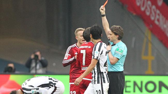 Referee Guido Winkmann shows a red card to Ingolstadt's Australian forward Mathew Leckie.