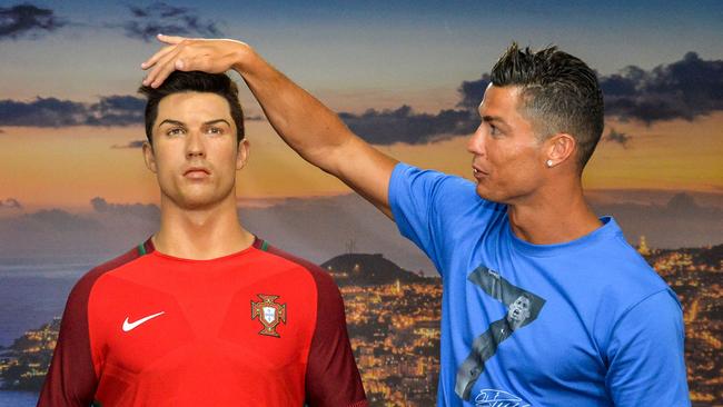 Portugese forward Cristiano Ronaldo poses next to a wax statue.