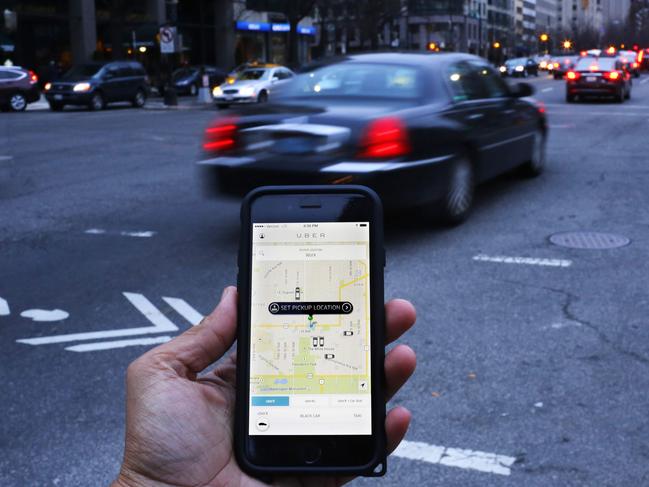 (FILES) In this file photo taken on March 25, 2015 An Uber application is shown as cars drive by in Washington, DC. - Uber is seeking to raise some $10 billion in what would be the largest stock offering of the year, with details coming this week, the Wall Street Journal reported on April 10, 2019. The global ride-hailing giant is seeking a valuation close to $100 billion -- an impressive figure but below some earlier estimates amid an ebbing of enthusiasm on growth and profitability, the report said. (Photo by Andrew CABALLERO-REYNOLDS / AFP)