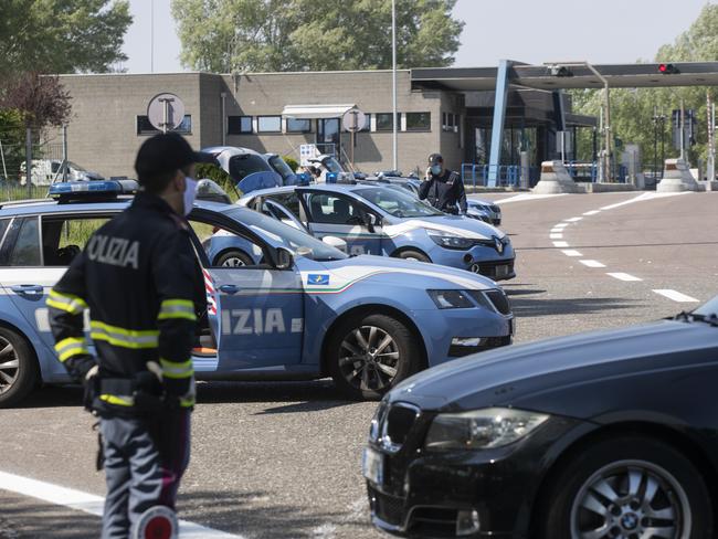 Police officers stop cars at the Melegnano highway barrier entrance, near Milan. Picture: AP